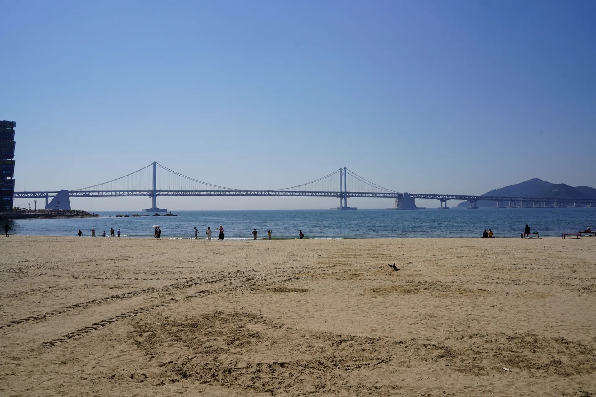 Walk along Gwangalli Beach facing the famous Gwangandaegyo cable-stayed bridge (northeast of Busan)