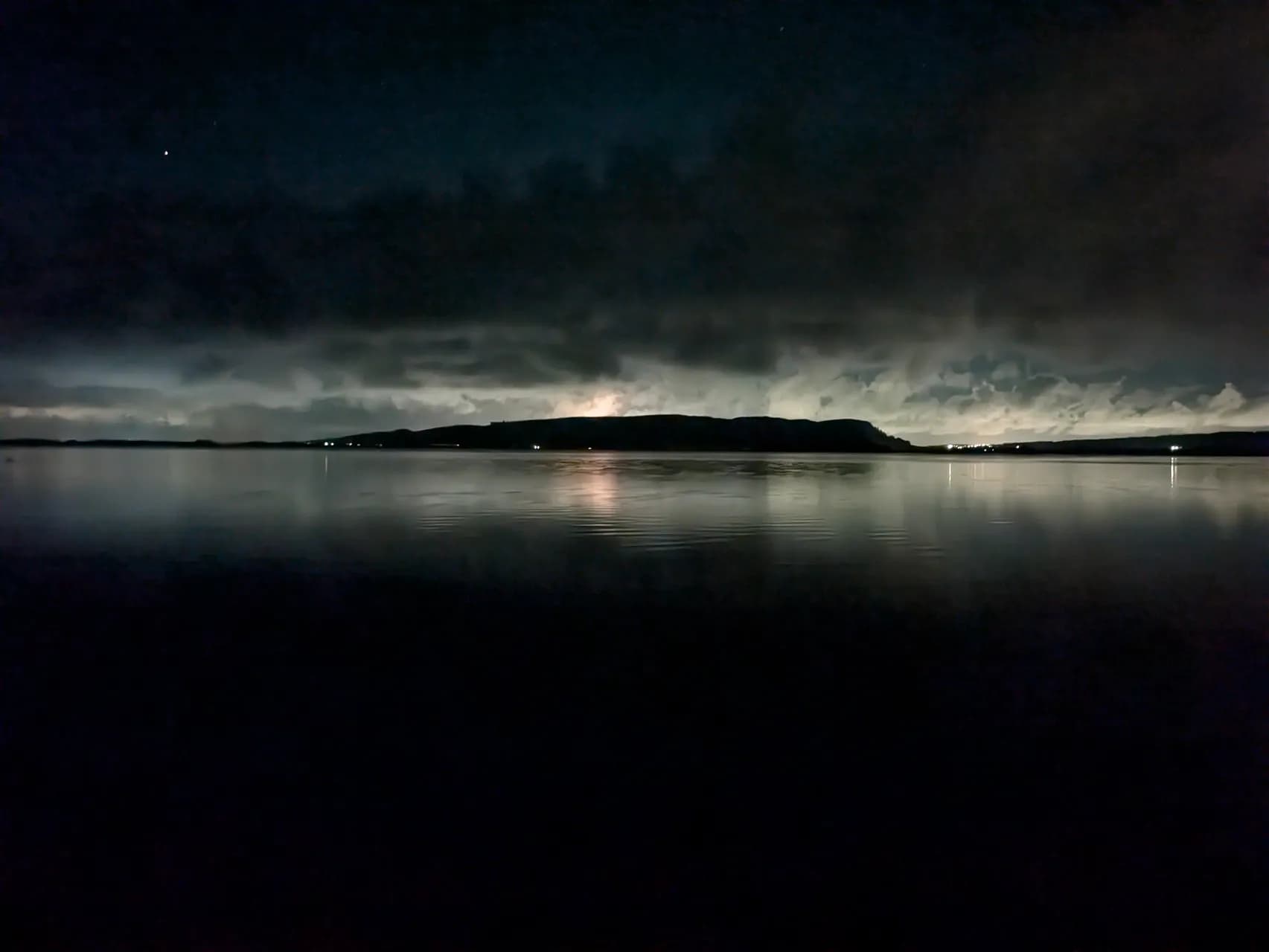 Nuit sur le parking de Burleygh dans le Loch Leven National Nature Reserve. Le parking est bien rempli même en ce début octobre. Belle photo nocturne avec les lumières de la ville en arrière plan