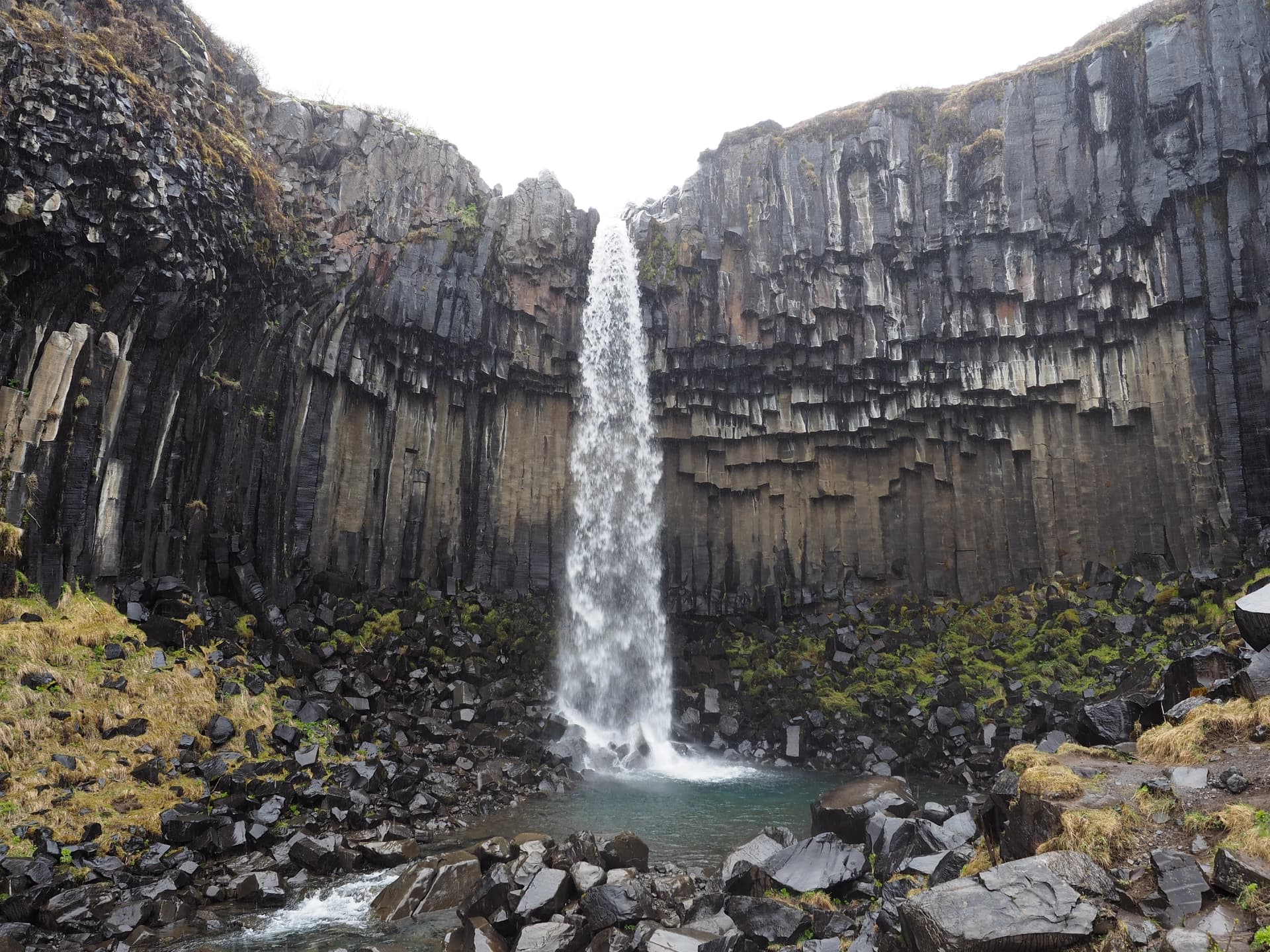 Randonnée dans le parc de Skaftafell. Chutes de Svartifoss de 20m devant un mur de colonnes en basalte hexagonales