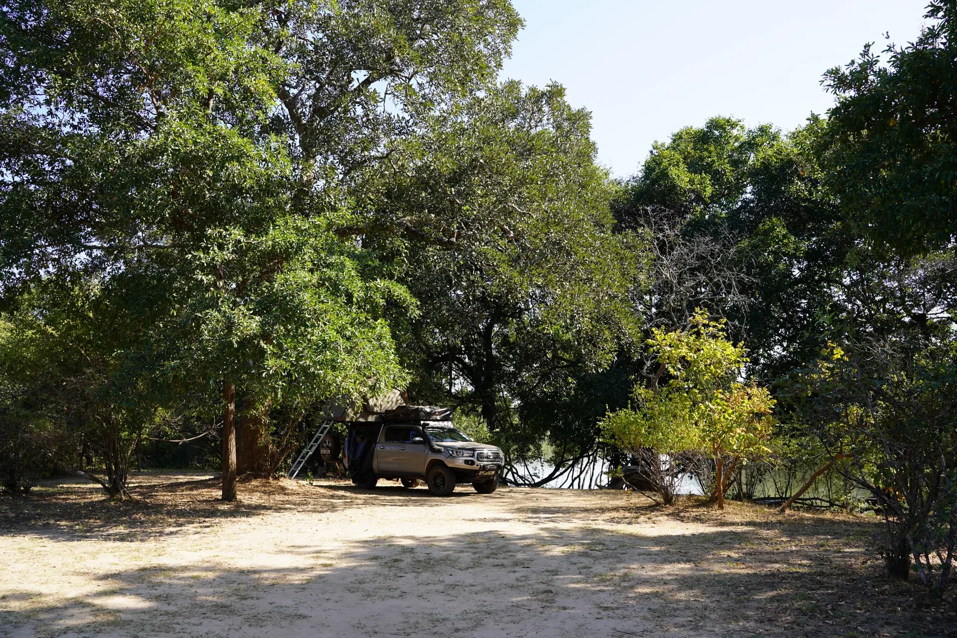 Campsite sur les berges ombragées de la rivière Kafue au Kasabushi bush camp